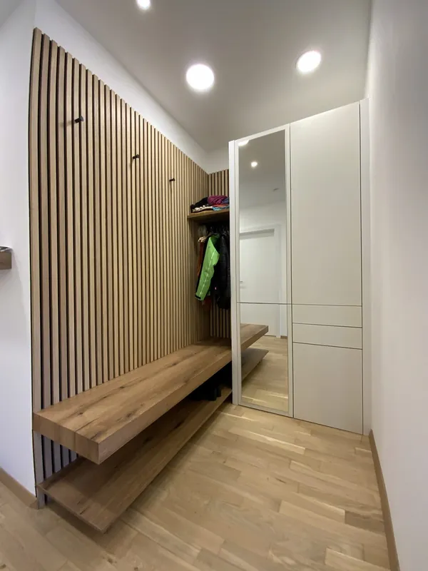 Garderobe mit Holzlamellen-Wand, schwebender Sitzbank aus Eiche und Einbauschrank