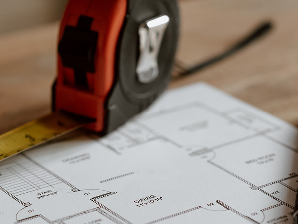 Maßband und Bauplan auf dem Tisch